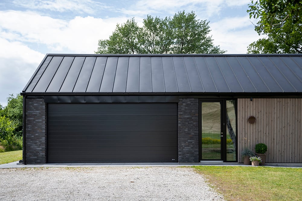 Nybygget design villa med sort Lindab garageport